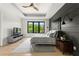 Stylish main bedroom with modern decor, wood accent wall, and scenic outdoor views at 5160 Howard Rd, Cumming, GA 30040
