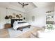 Bright main bedroom with white walls, tray ceiling, modern lighting, hardwood floors, and ensuite bathroom at 5160 Howard Rd, Cumming, GA 30040