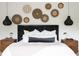 Close up of the main bedroom with textured headboard, unique pendants, and decorative woven wall hangings at 5160 Howard Rd, Cumming, GA 30040