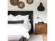 Textured headboard with unique pendants, decorative woven wall hangings, and hardwood floors in the main bedroom at 5160 Howard Rd, Cumming, GA 30040