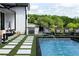 Luxury pool features a built-in grilling station, multiple lounge chairs, and turf stone design at 5160 Howard Rd, Cumming, GA 30040