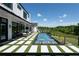 A stunning modern pool with water features surrounded by green turf and patio, backing onto a scenic view at 5160 Howard Rd, Cumming, GA 30040