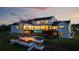 Stunning modern farmhouse boasts a unique glass-bottom pool and outdoor fire pit at twilight at 5160 Howard Rd, Cumming, GA 30040