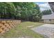 Landscaped backyard with a retaining wall and mature trees at 1045 River Valley Dr, Dacula, GA 30019