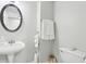 Powder bathroom featuring modern fixtures, including a pedestal sink and toilet at 1045 River Valley Dr, Dacula, GA 30019