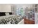 Bright bedroom with shoe storage, a patterned comforter, and hardwood floors at 1045 River Valley Dr, Dacula, GA 30019