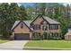 Charming two-story brick home featuring a well-manicured lawn and attached two-car garage at 1045 River Valley Dr, Dacula, GA 30019