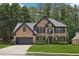 Charming two-story brick home with a manicured lawn, black trim, and attached two-car garage at 1045 River Valley Dr, Dacula, GA 30019