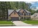 Charming two-story brick home with a manicured lawn, black trim, and attached two-car garage at 1045 River Valley Dr, Dacula, GA 30019