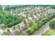 Aerial view of a neighborhood featuring a two-story home and green lawns and mature trees at 1370 Sunnys Halo Dr, Suwanee, GA 30024