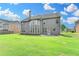 Spacious backyard with green lawn and home's rear exterior featuring multiple windows at 1370 Sunnys Halo Dr, Suwanee, GA 30024