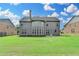 Spacious backyard with green lawn and home's rear exterior featuring multiple windows at 1370 Sunnys Halo Dr, Suwanee, GA 30024