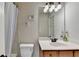 Well-lit bathroom featuring a white sink, mirror, and shower with curtain at 1370 Sunnys Halo Dr, Suwanee, GA 30024