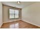 Well-lit bedroom with hardwood floors, neutral walls, large window with blinds at 1370 Sunnys Halo Dr, Suwanee, GA 30024