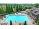 Aerial view of the community pool and lounge chairs, a pool house, playground, landscaping, and trees at 1370 Sunnys Halo Dr, Suwanee, GA 30024