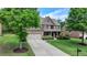 Charming two-story home with a well-manicured lawn, mature trees, and a two-car garage at 1370 Sunnys Halo Dr, Suwanee, GA 30024