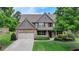 Beautifully landscaped front exterior with brick accents, a two-car garage, and a well-kept lawn at 1370 Sunnys Halo Dr, Suwanee, GA 30024
