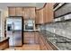 Kitchen featuring stainless steel appliances, granite counters, gas stove, and wooden cabinets at 1370 Sunnys Halo Dr, Suwanee, GA 30024