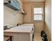 Functional laundry room with side by side washer and dryer, shelving and natural light at 1370 Sunnys Halo Dr, Suwanee, GA 30024