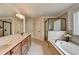 Bright main bathroom with double vanity, soaking tub, and glass shower at 1370 Sunnys Halo Dr, Suwanee, GA 30024