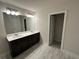 Bright bathroom featuring a double vanity with dark cabinets, tile floors, and modern lighting at 257 Depot Landing Rd # 39, Auburn, GA 30011
