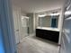 Bathroom featuring a double vanity with dark cabinets, tile floors, and a glass enclosed shower at 257 Depot Landing Rd # 39, Auburn, GA 30011