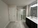 Bathroom featuring a single vanity with dark cabinets, tile floors, and a glass enclosed shower at 257 Depot Landing Rd # 39, Auburn, GA 30011