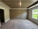 Spacious bedroom featuring plush carpeting, horizontal shiplap accent wall, tray ceiling, and a bright window at 257 Depot Landing Rd # 39, Auburn, GA 30011