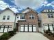 Charming townhome with brick facade, white siding, and a two-car garage at 257 Depot Landing Rd # 39, Auburn, GA 30011
