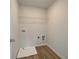 The laundry room features wood-look floors, washer and dryer hookups and a white wire shelf at 257 Depot Landing Rd # 39, Auburn, GA 30011
