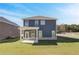 Backyard view of a two-story home featuring a covered patio and well-maintained lawn at 266 Tulip Dr, Covington, GA 30016