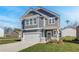 Charming two-story home with gray siding, white trim, a covered entrance, and a two-car garage at 266 Tulip Dr, Covington, GA 30016