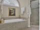 Well-lit bathroom showcasing a large soaking tub and a glass-enclosed shower with tiled surround at 4566 Fountain Ne Dr, Marietta, GA 30067