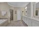 Bright bathroom featuring double sinks with white cabinets, a soaking tub, and a glass-enclosed shower at 4566 Fountain Ne Dr, Marietta, GA 30067