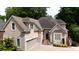 Charming home featuring a two-car garage, beautiful landscaping, and a welcoming front porch area at 4566 Fountain Ne Dr, Marietta, GA 30067