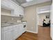 Basement kitchenette with white cabinets and appliances, with exercise room just beyond at 4566 Fountain Ne Dr, Marietta, GA 30067