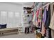 Organized walk-in closet with shelving, hanging rods, and bench seating for convenient storage at 4566 Fountain Ne Dr, Marietta, GA 30067