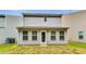View of the back of the home with a door, multiple windows, and a lawn at 7630 Volion Pkwy, Fairburn, GA 30213