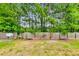 The backyard has a fenced in yard and is surrounded by tall trees at 7630 Volion Pkwy, Fairburn, GA 30213