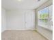 Well-lit bedroom featuring plush carpeting and natural light streaming through the window at 7630 Volion Pkwy, Fairburn, GA 30213