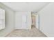 Bright bedroom featuring carpeted floors, a door, and a window with natural light at 7630 Volion Pkwy, Fairburn, GA 30213