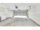 Spacious unfinished garage with exposed drywall and a partially open garage door at 7630 Volion Pkwy, Fairburn, GA 30213