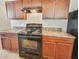 Close up of the black oven range and wood cabinets at 7630 Volion Pkwy, Fairburn, GA 30213