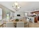 Bright dining area featuring modern chandelier and an open view of the kitchen with a breakfast bar at 7630 Volion Pkwy, Fairburn, GA 30213