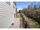 Side and backyard featuring a small concrete patio, surrounded by lush trees and a side fence at 853 Bentley Drive Dr, Fairburn, GA 30213