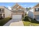 Charming two-story home featuring a brick facade and a two-car garage, set against a bright sky at 853 Bentley Drive Dr, Fairburn, GA 30213
