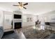 Open living room featuring hardwood floors, modern furnishings, a fireplace, and a kitchen view at 853 Bentley Drive Dr, Fairburn, GA 30213