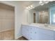 Bathroom featuring dual sinks, framed mirror, and walk-in closet view at 107 St Annes Pl, Covington, GA 30016