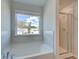 Bathroom featuring soaking tub, walk-in shower, and window view at 107 St Annes Pl, Covington, GA 30016