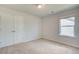 Cozy bedroom featuring neutral walls, carpet, and a double door closet at 107 St Annes Pl, Covington, GA 30016